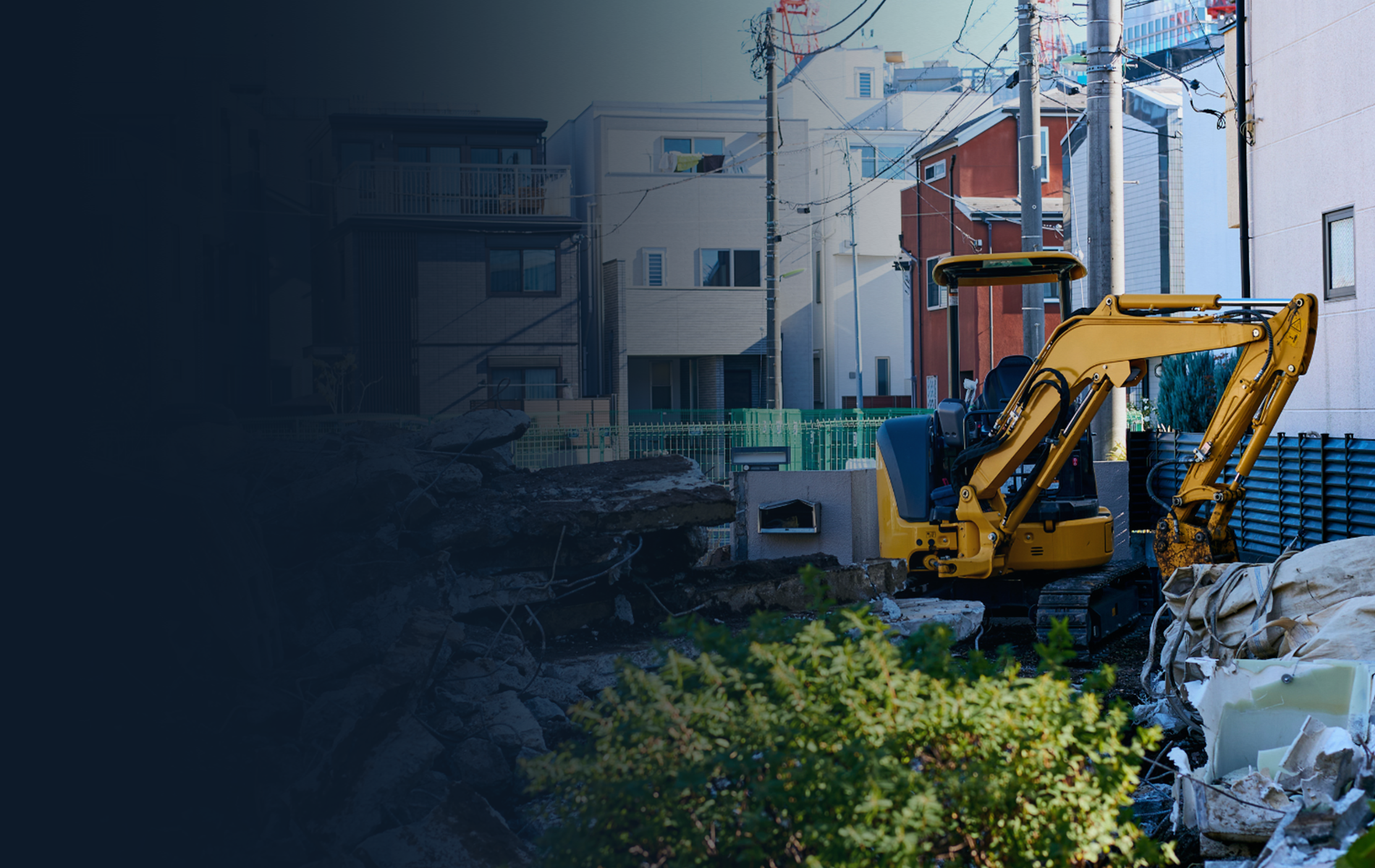 Yellow excavator at a construction site in a residential area.