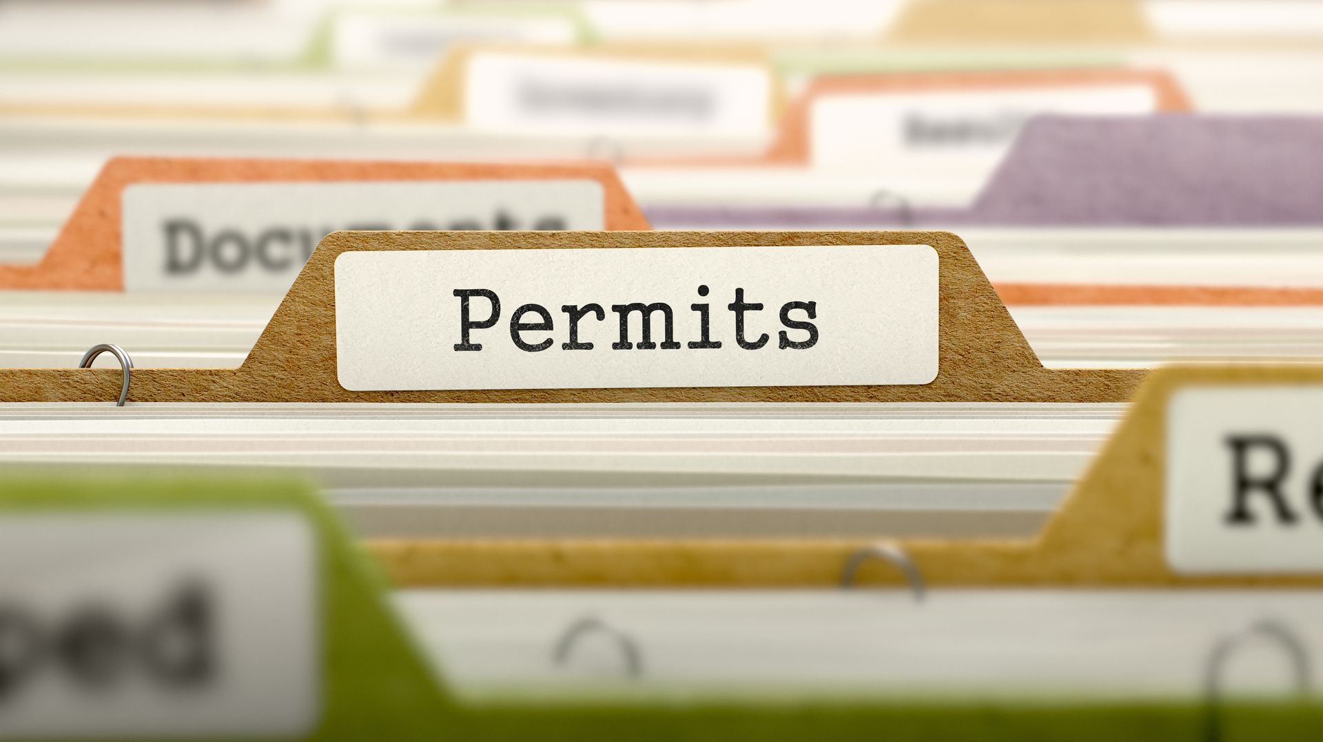 A row of binders with one labeled permits