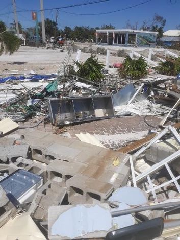 Debris-covered street and damaged buildings after a disaster.