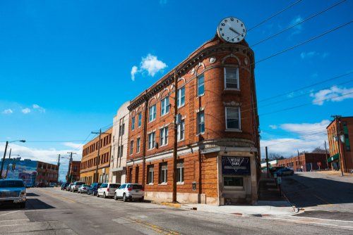 Brick corner building with a clock tower on a sunny city street