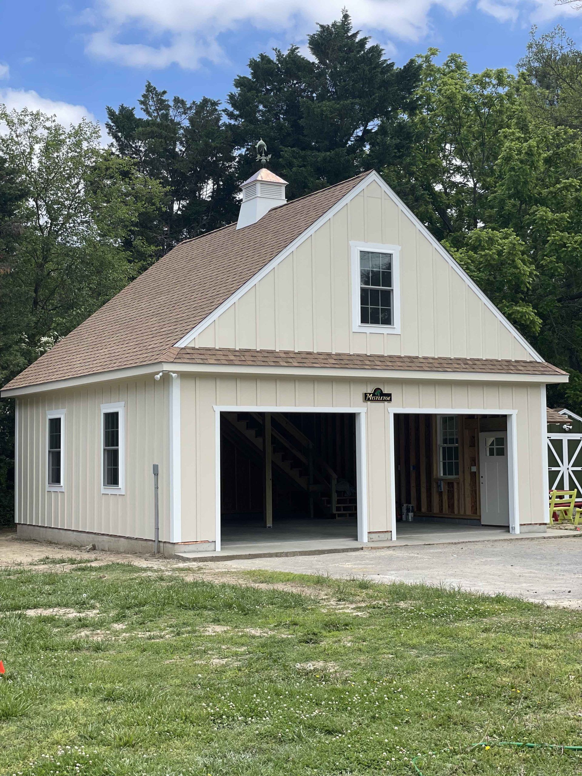 A white garage with a brown roof is being built