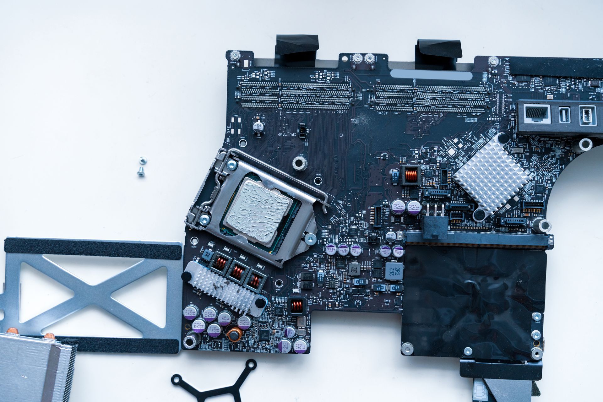 Una scheda madre di un computer smontata con processore e vari componenti 