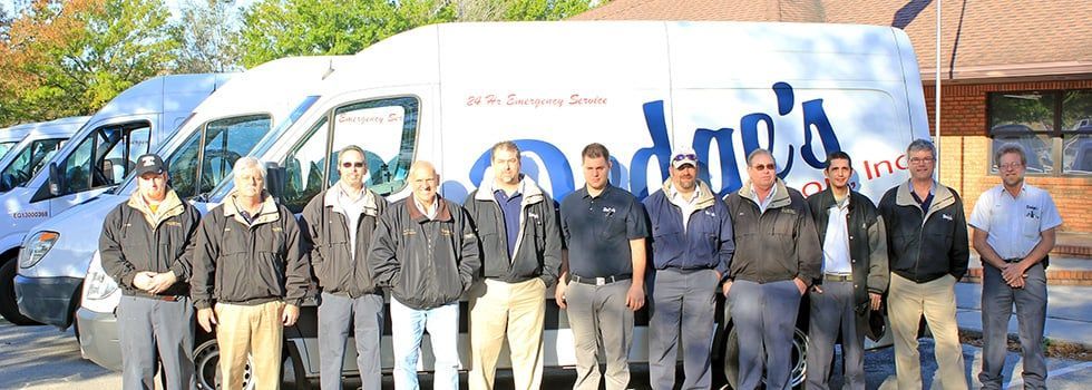 A group of men are posing for a picture in front of a white van that says ' anderson 's ' on it