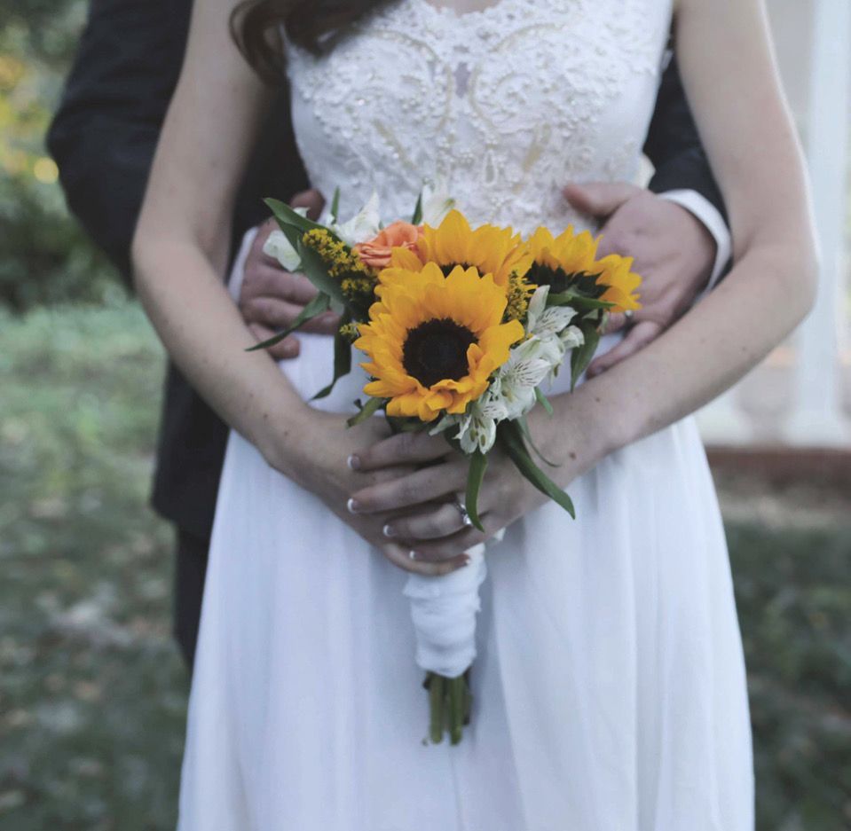 bride holding a bouquet of sunflowers