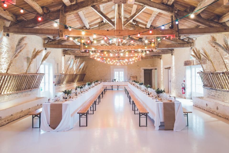 a long white table is set for a wedding