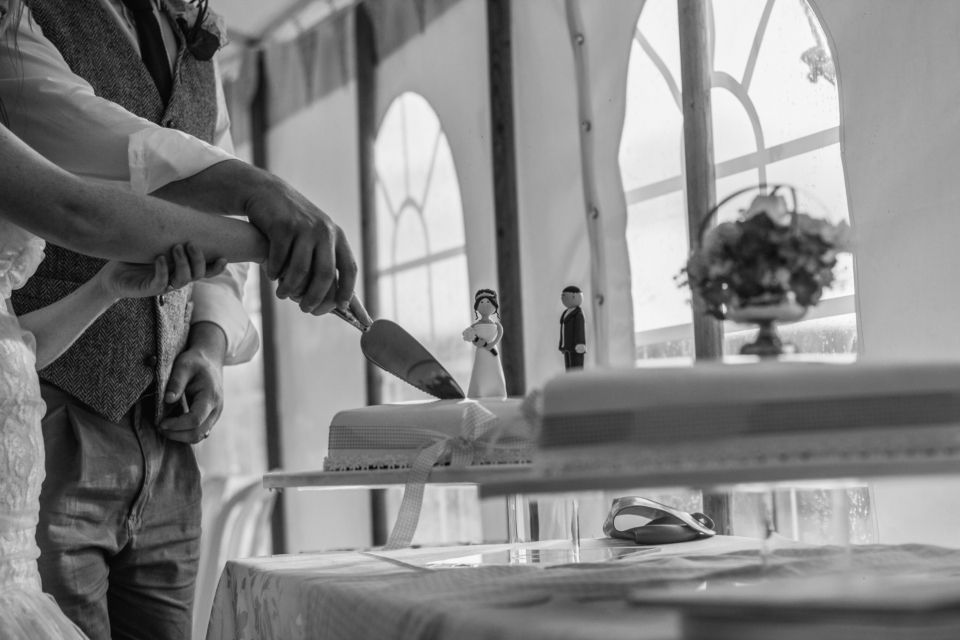 a man and a woman cut a wedding cake