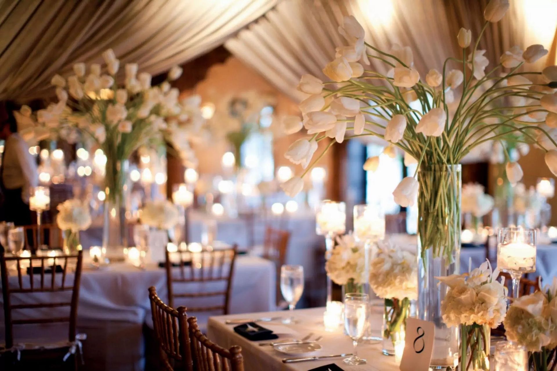 un tavolo è decorato per un matrimonio con fiori bianchi e candele
