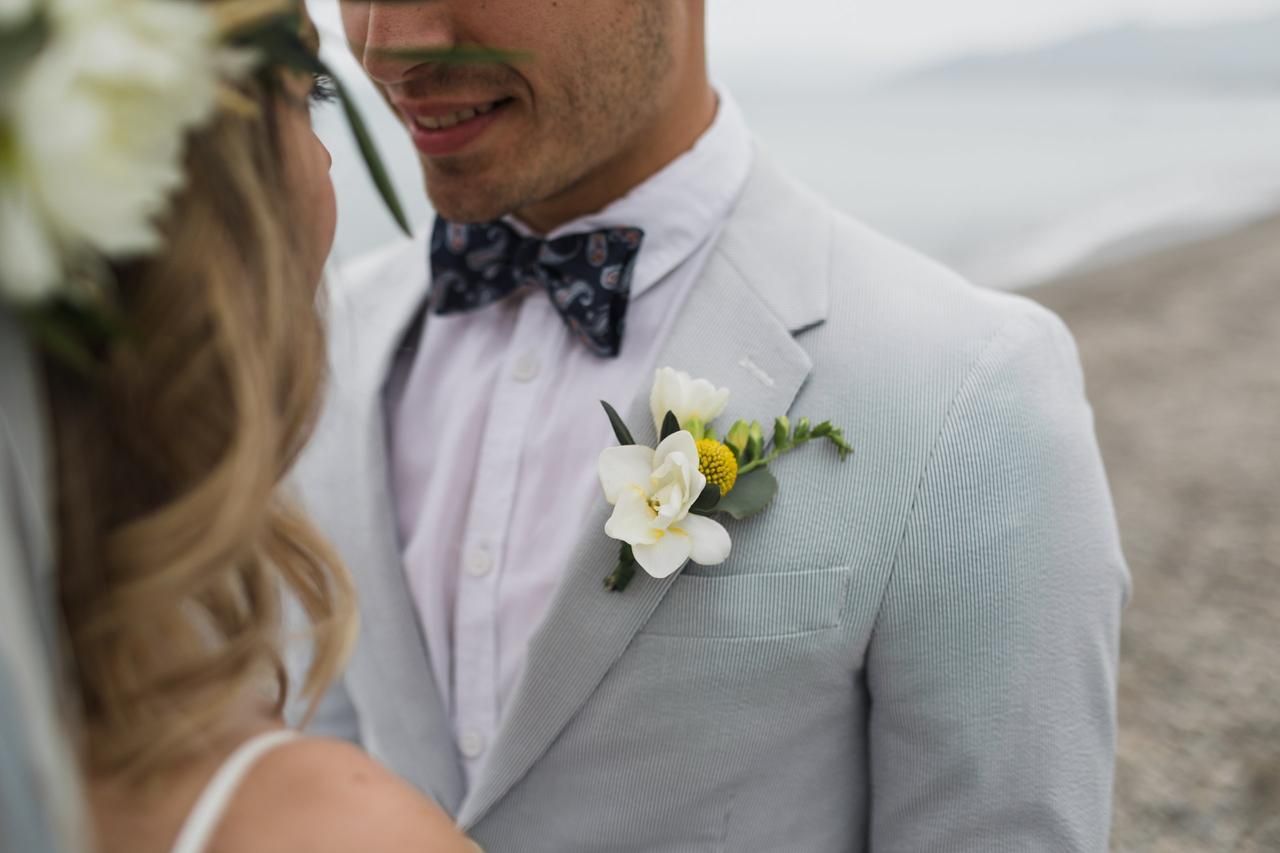 un uomo in giacca e papillon è in piedi accanto a una donna che indossa una corona di fiori