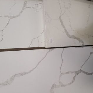White marble tile samples with gray veining, arranged in a grid.