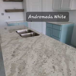 Andromeda White granite kitchen countertop with double sink and blue cabinets