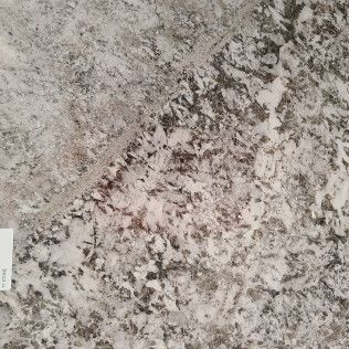 Close-up of a gray, white, and black speckled stone surface with a small label on the left edge