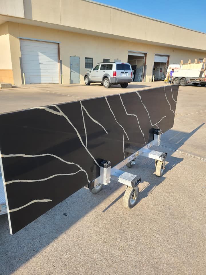 Large black stone slab on a wheeled cart in an industrial loading area