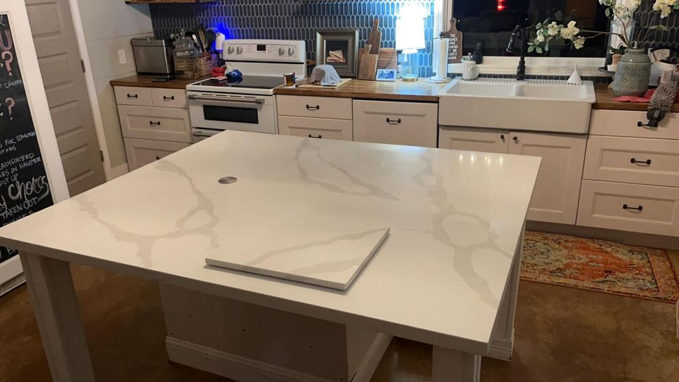 White marble kitchen island with a notebook in a bright, modern kitchen