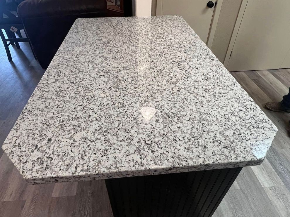Speckled white granite tabletop on a dark base, shown indoors from above.
