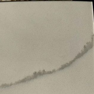 A gray background with a faint diagonal line or crack across the lower half.
