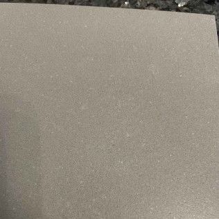 Close-up of a gray, textured surface with a dark edge in the top left corner