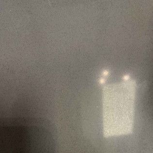 Dim gray scene with a small white rectangular object lit by three bright points above it.
