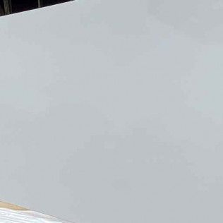 Blank light gray surface with a small tan edge in the lower-left corner