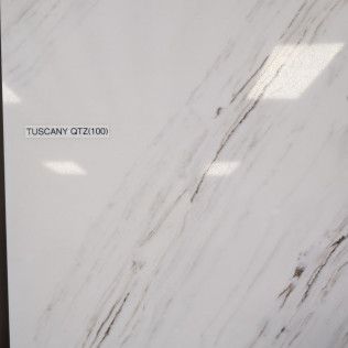 White marble-look tile with subtle gray veining and the label “TUSCANY QTZ001”