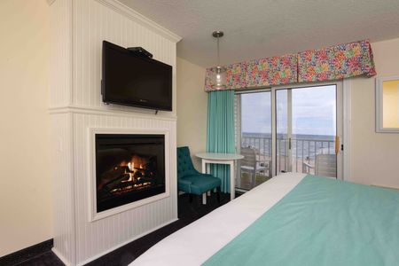 A hotel room with a fireplace and a flat screen tv.