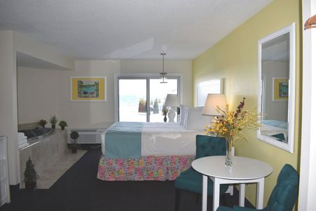 A hotel room with a large bed a table and chairs