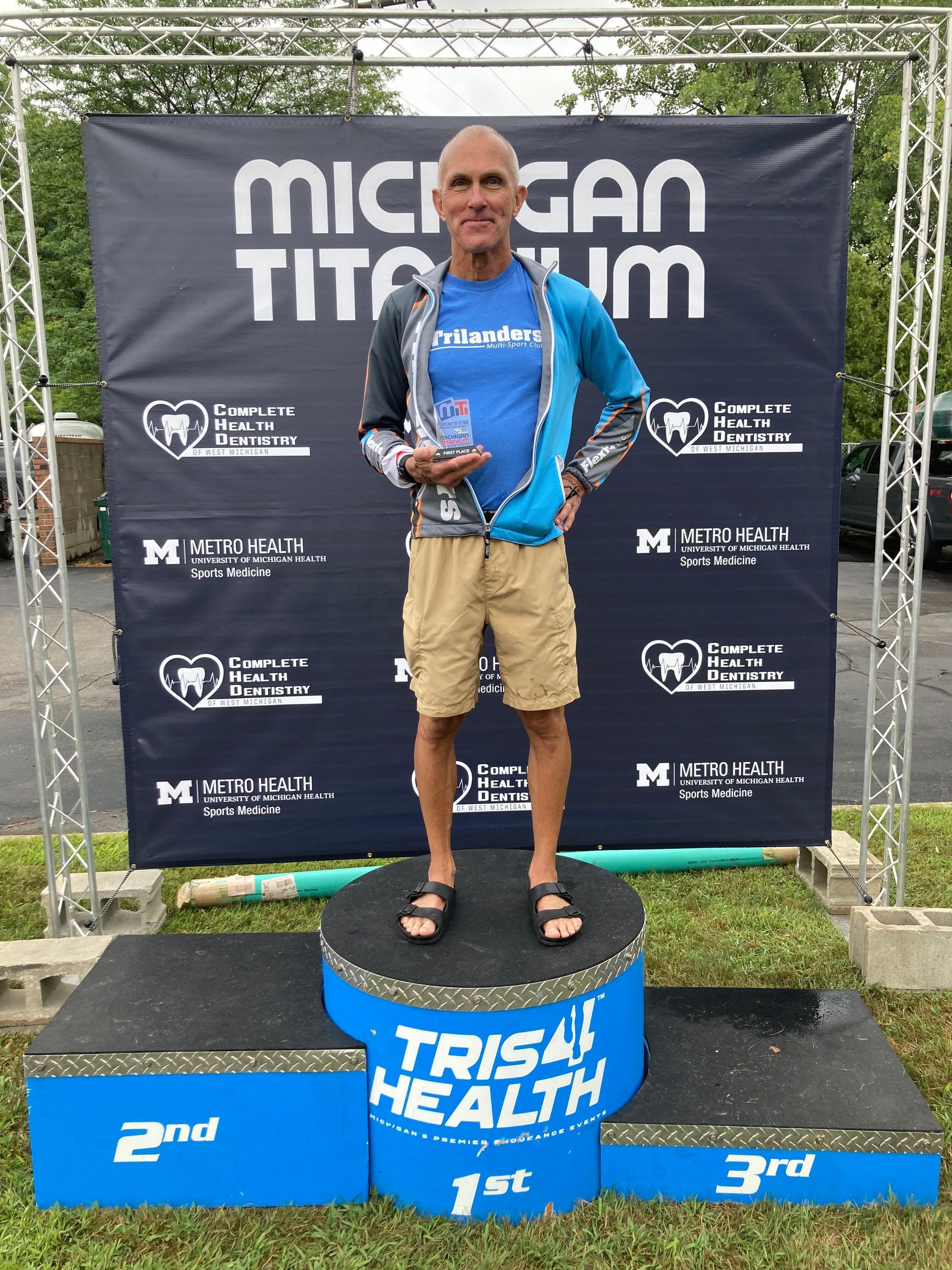 A man is standing on a podium that says trisa health