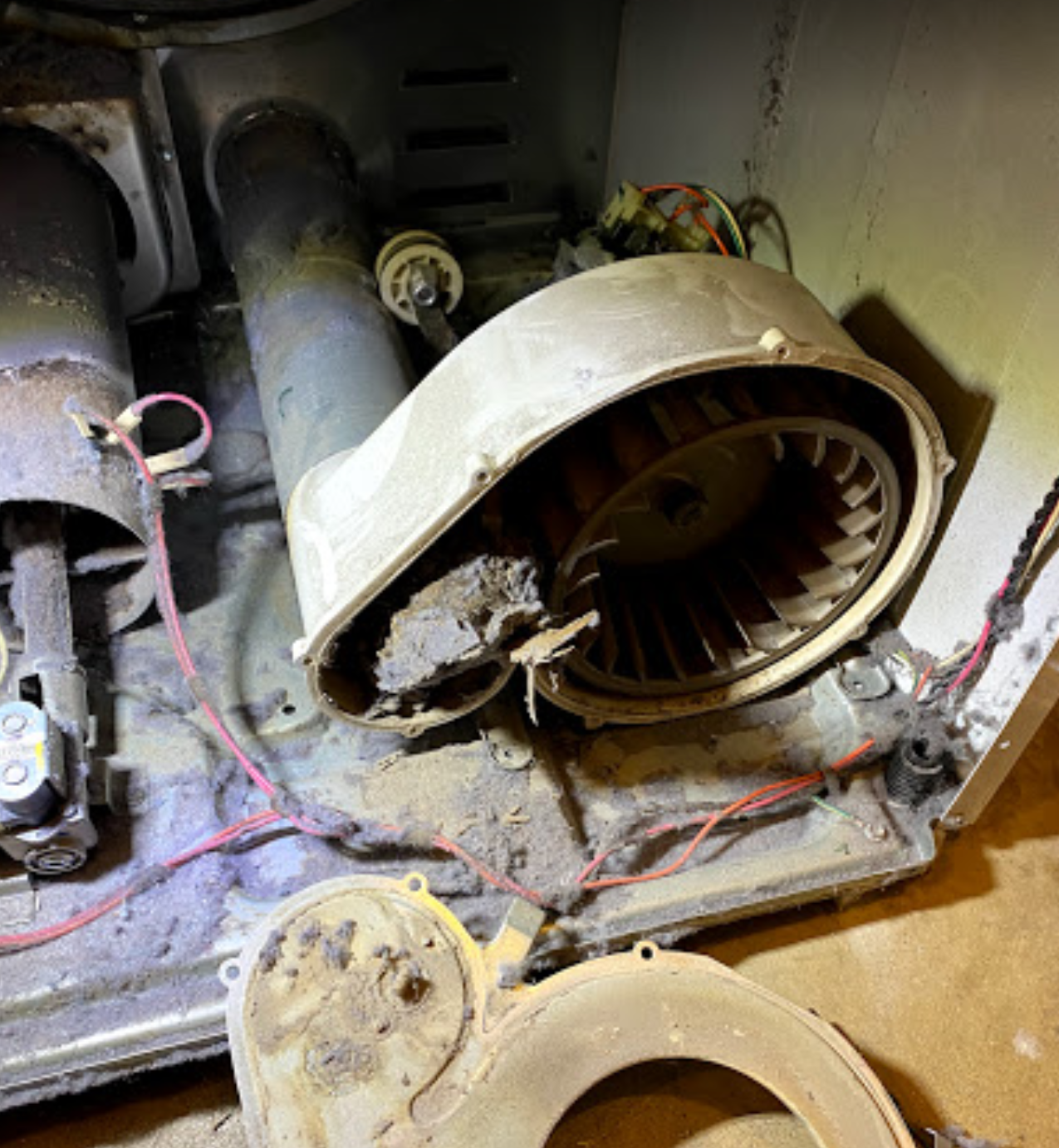 A dirty blower is sitting on top of a dirty stove.