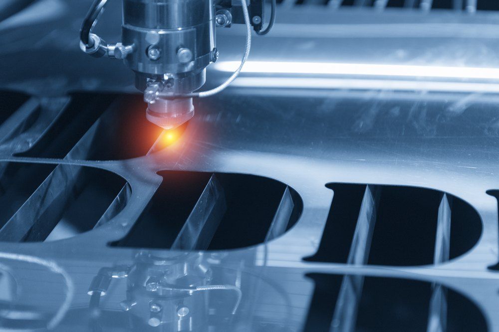 A Machine is Cutting a Piece of Metal With the Letter D on It — Signtek Gladstone in Gladstone Central, QLD