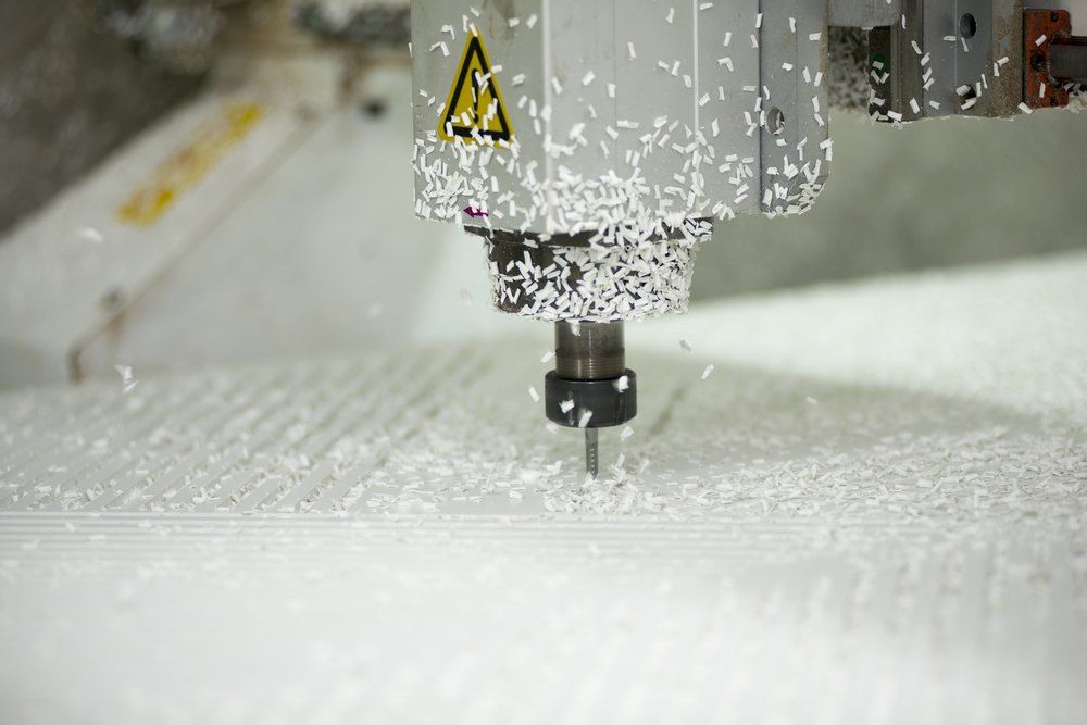 A Machine is Cutting a Piece of White Plastic — Signtek Gladstone in Gladstone Central, QLD