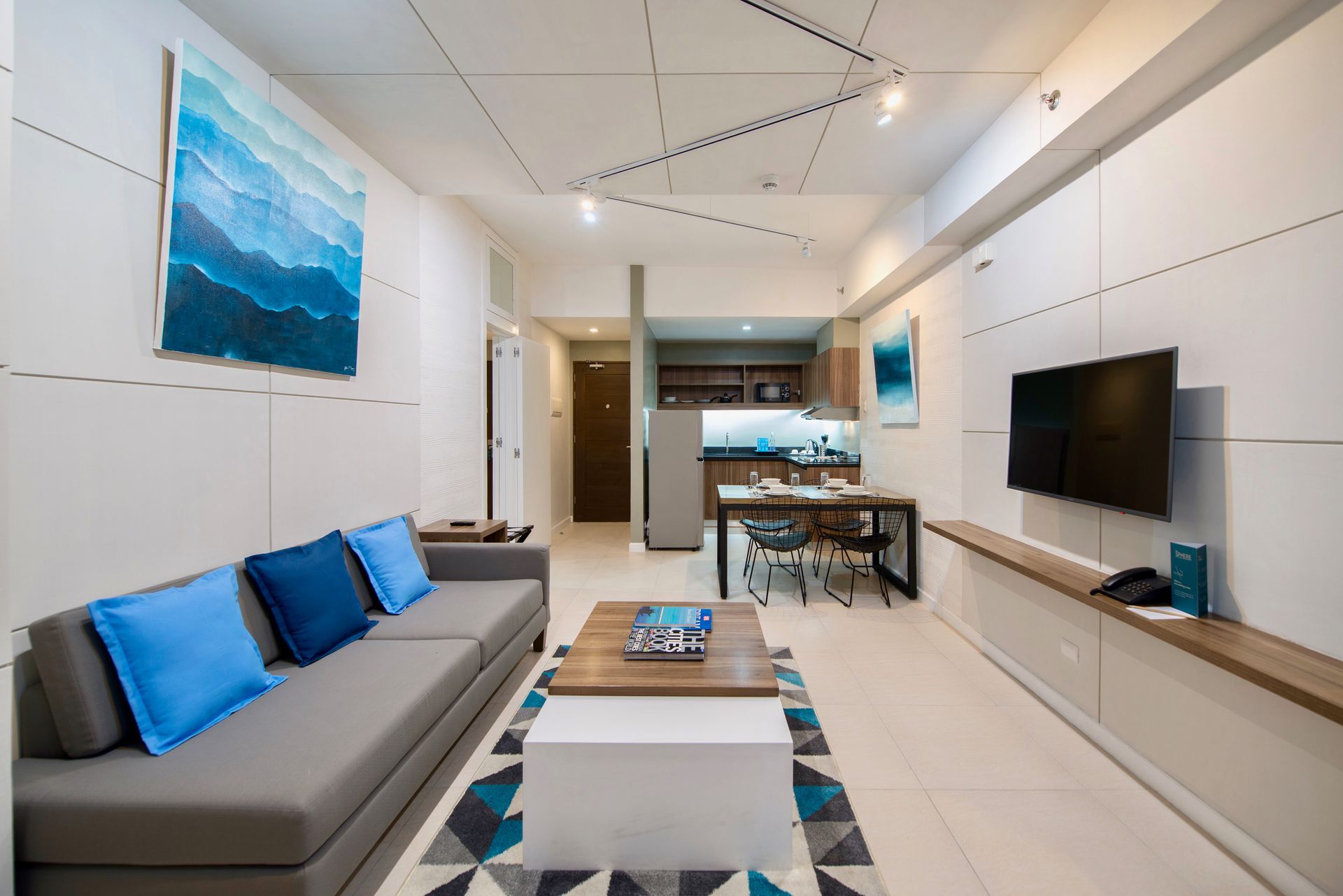 Full view of a serviced apartment at The Sphere Makati from the living area through to the dining nook and kitchen