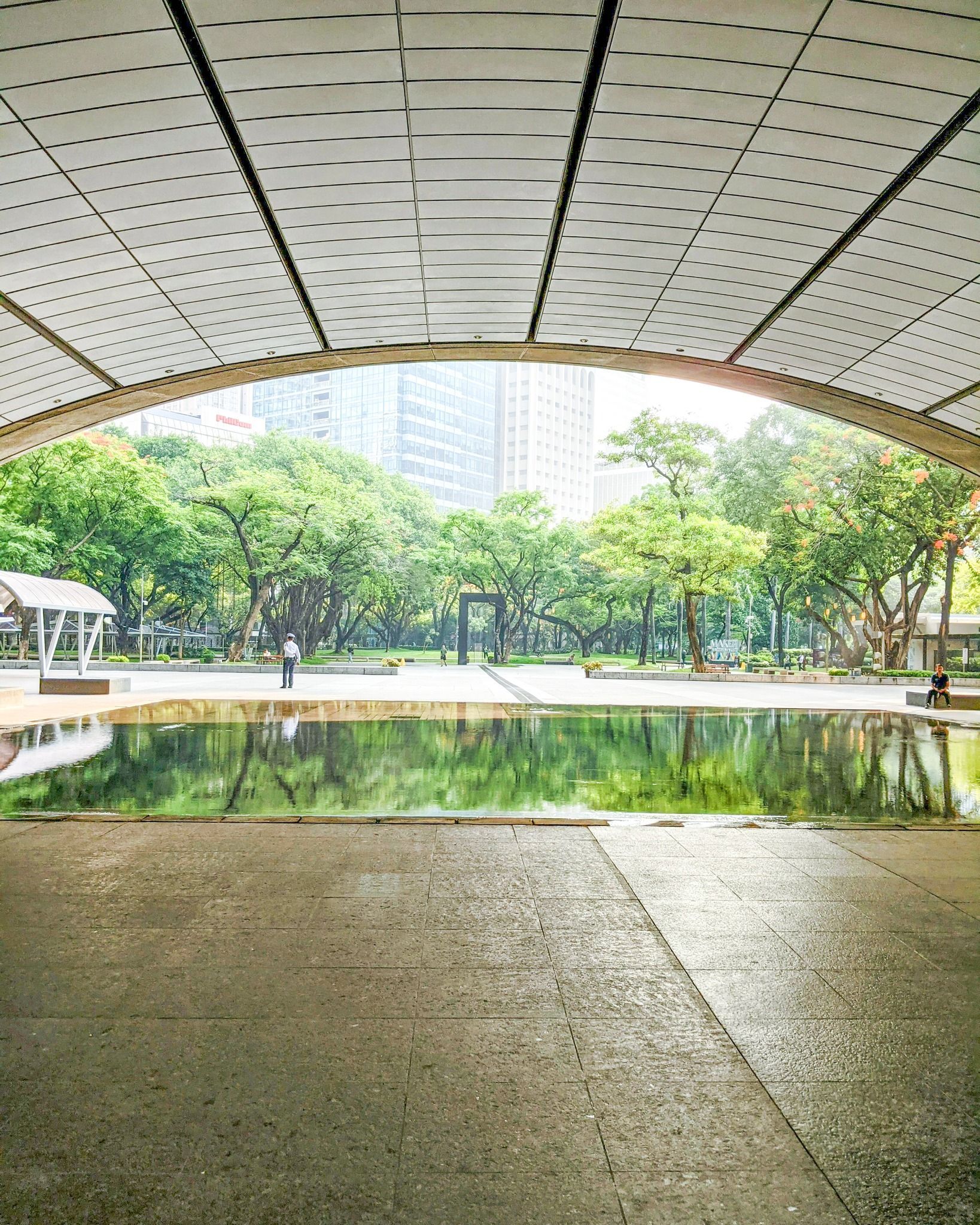 Scenic park with reflection pool and arch canopy near Makati hotels