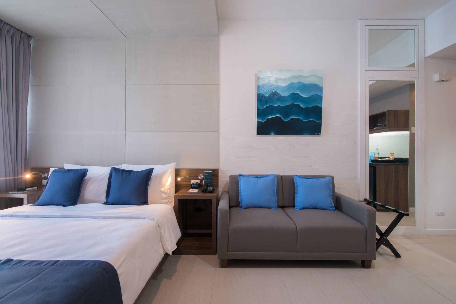 Modern hotel room with king bed and blue accents at The Sphere Makati