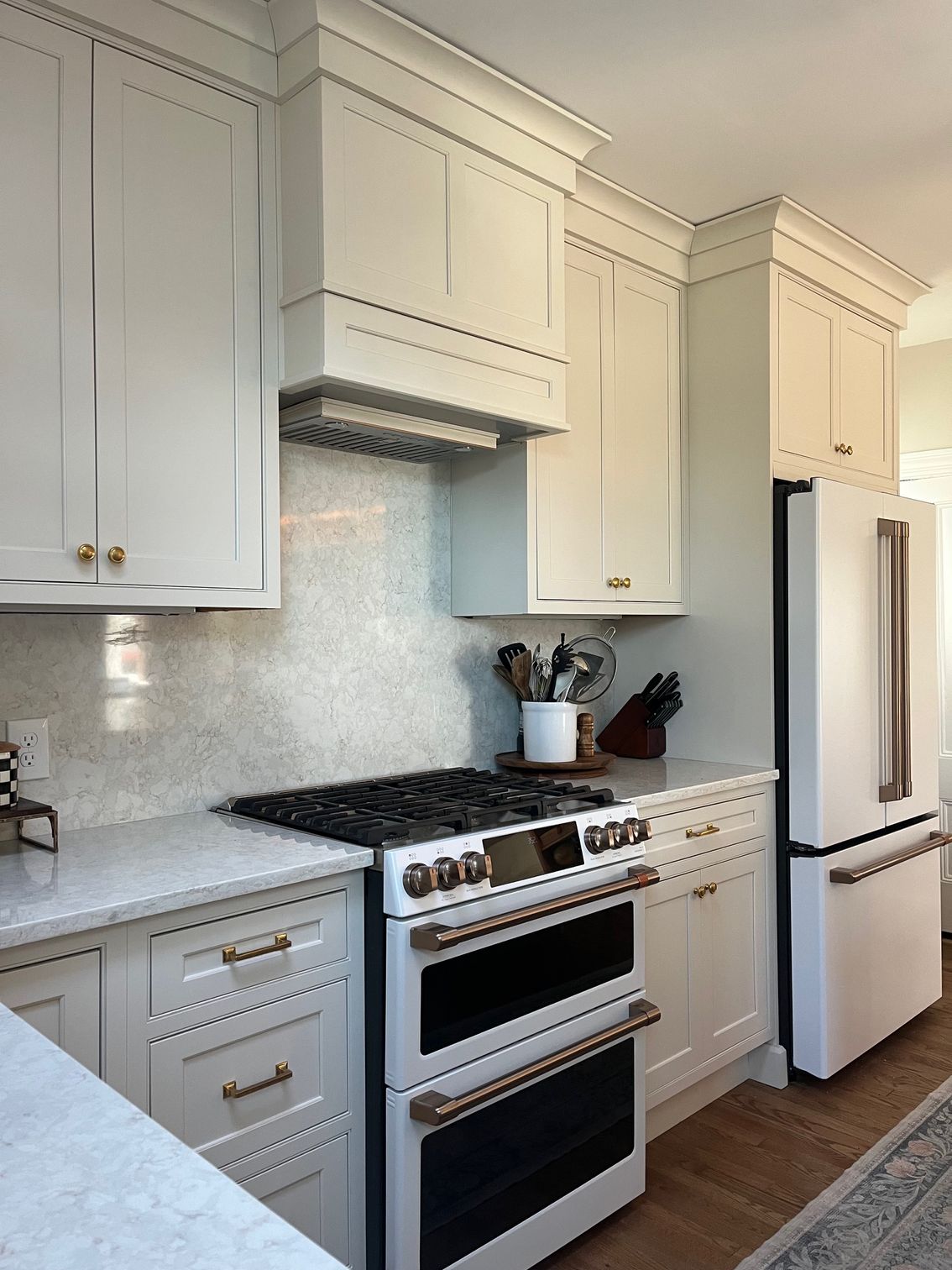 A kitchen with white cabinets , a stove and a refrigerator