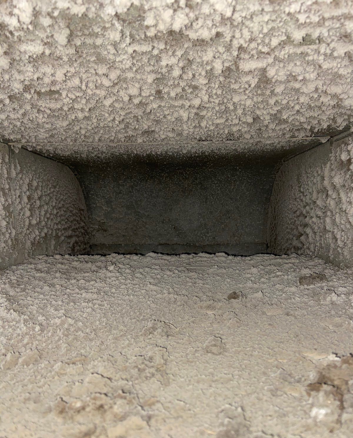 A close up of a dirty duct with a hole in the middle.