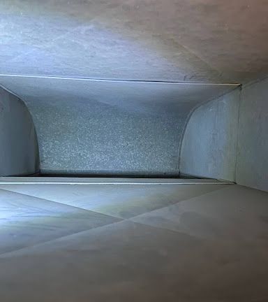 A close up of the inside of a clean duct with a light shining on it.