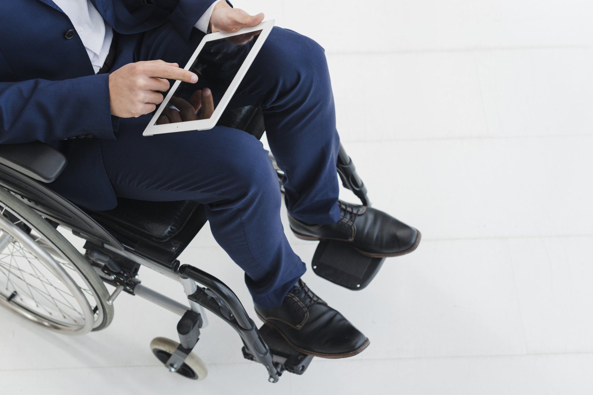 man sitting in wheelchair with ipad