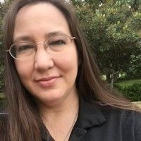 nicole cook A woman wearing glasses and a black shirt is smiling for the camera.