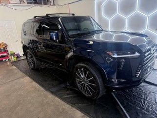 Black SUV parked indoors beside a hexagonal LED wall, viewed from the front-left angle