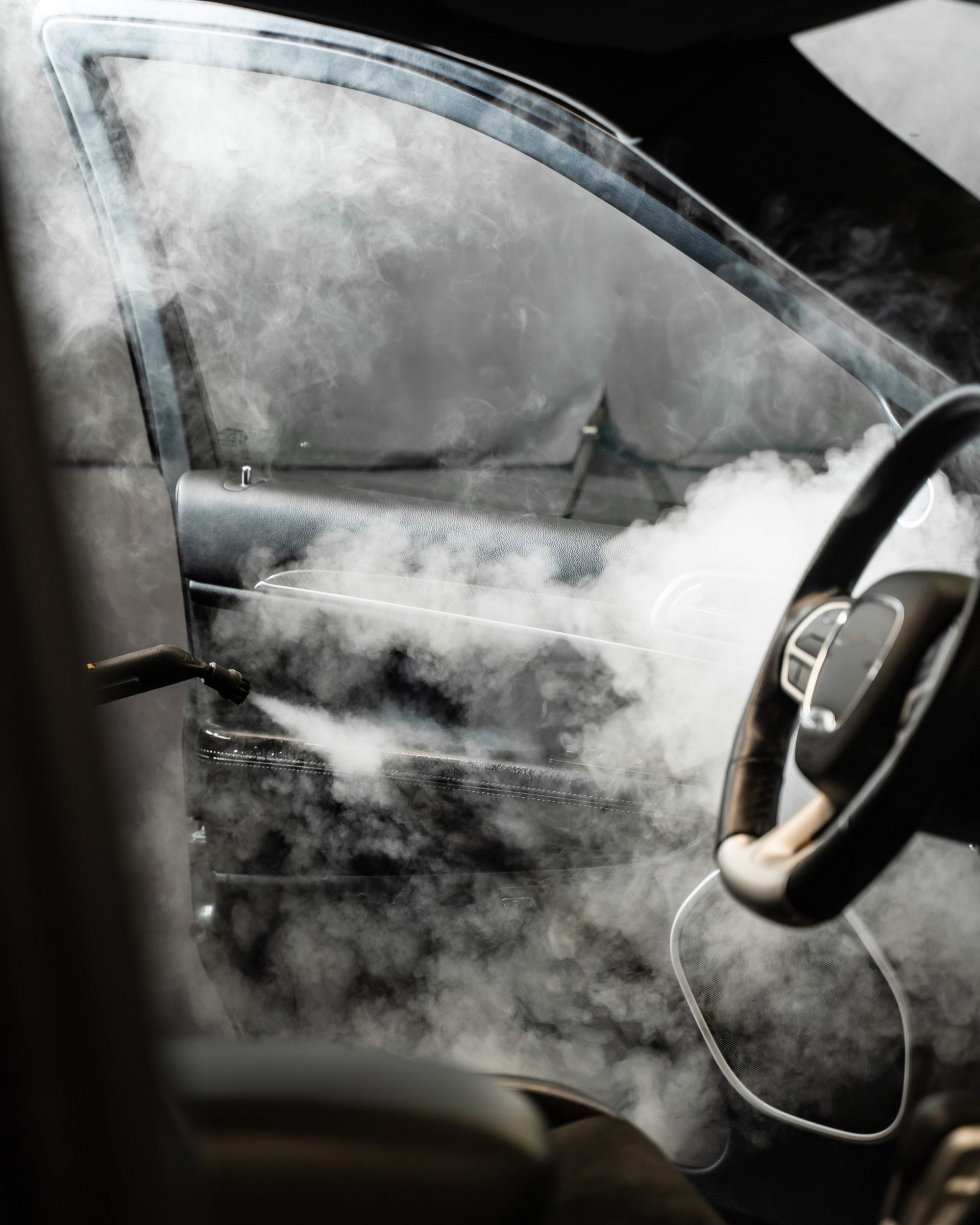 Steamy car interior with fogged windows and a visible steering wheel.