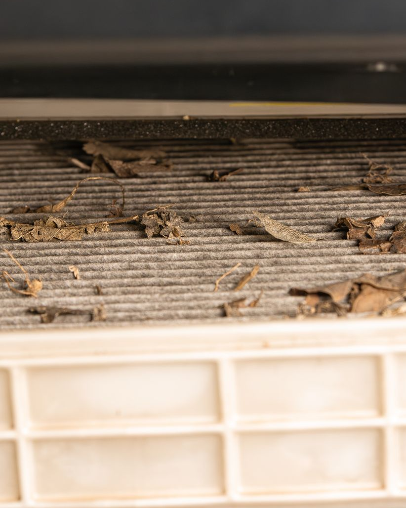 Dirty air filter with dust and debris buildup inside a vent opening