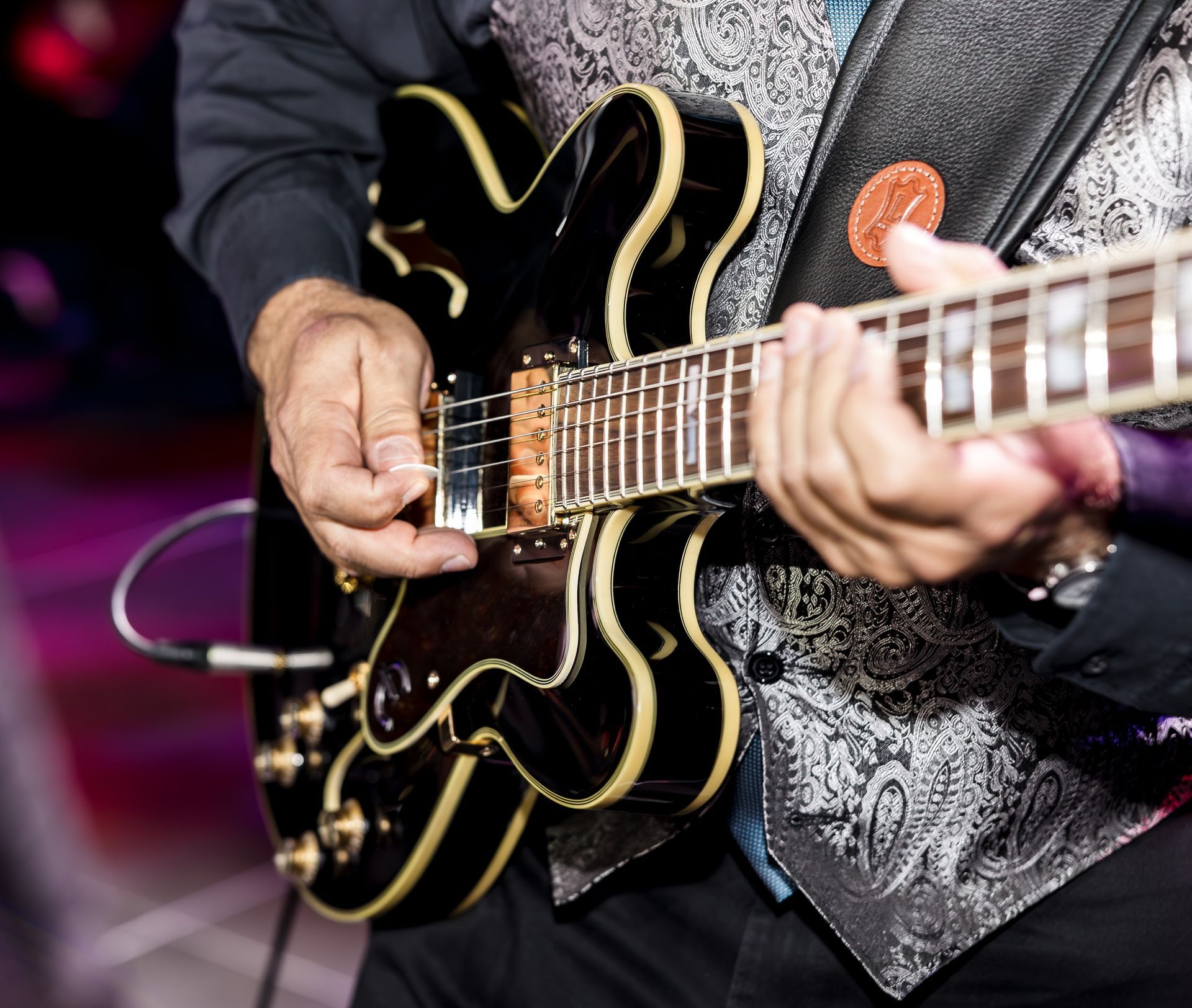 Close up picture of man playing electric guitar.