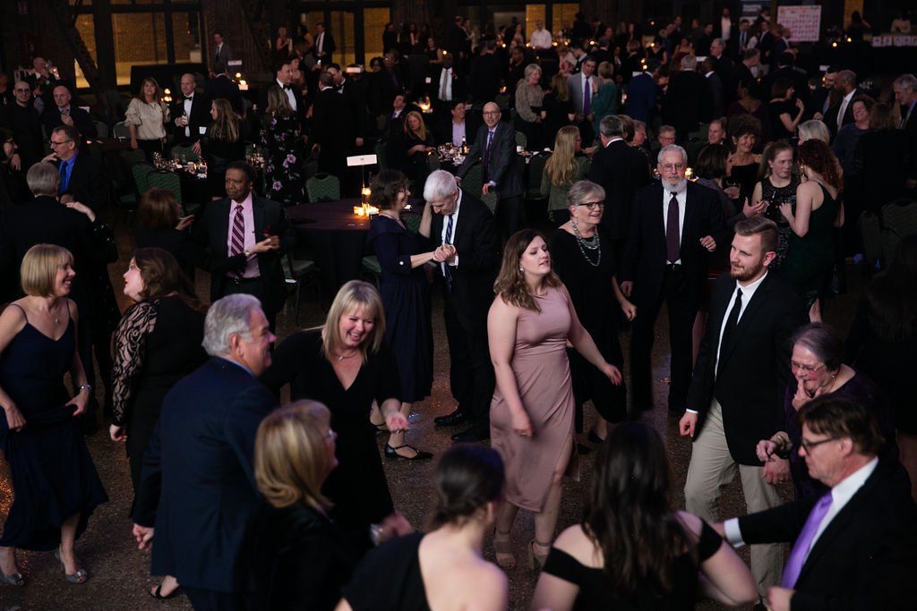 A large group of people are dancing at a party.