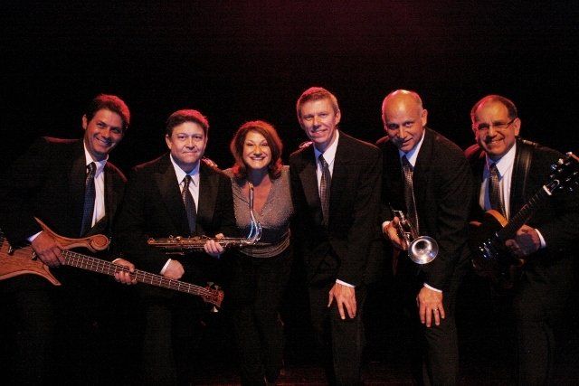 A group of people standing next to each other holding musical instruments.