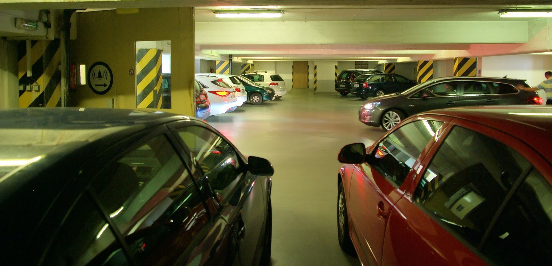 Řada aut parkuje v garáži.