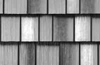 Close-up of overlapping gray wooden shingles with vertical grain patterns