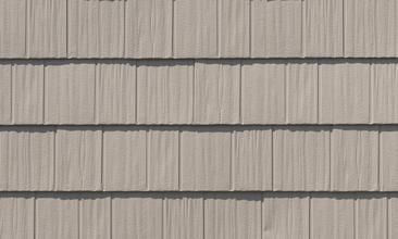 Close-up of beige shingle siding with horizontal gray trim lines
