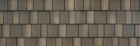 Brown-gray brick wall with a repeating rectangular pattern and slight discoloration.