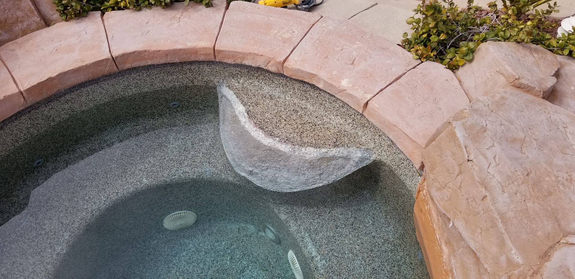A hot tub with a rock in the middle of it