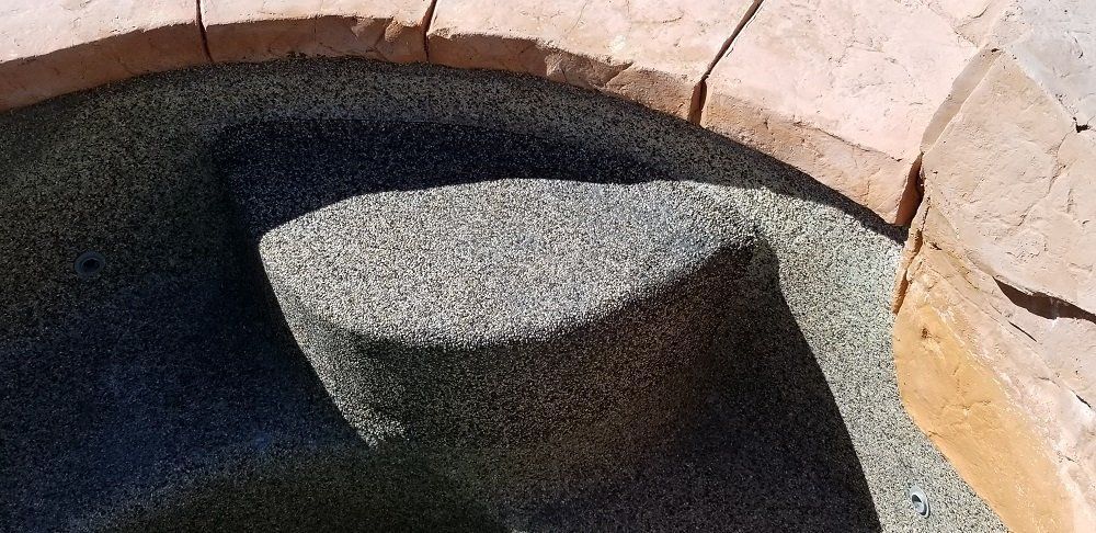 A shadow of a rock is cast on a concrete surface.