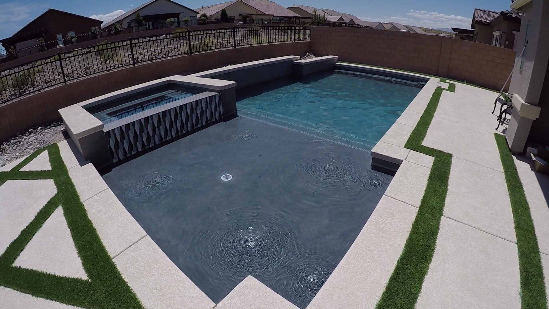 A large swimming pool with a hot tub in the middle of it.